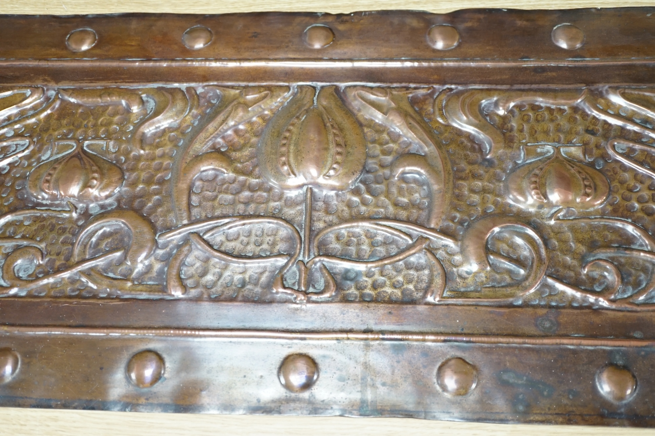 An Art Nouveau copper panel, embossed with stylised flowers and roundels, 39 x 99cm. Condition - fair